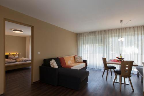 a living room with a couch and a bed at Alpenblick Nr 6 in Campo Tures