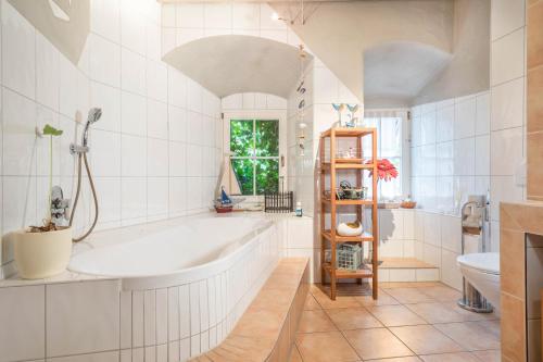 a white bathroom with a tub and a sink at Lemkamp groß in Markdorf