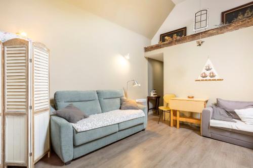 una sala de estar con un sofá y una cama en L' Eclose Ty Du, en Le Guilvinec