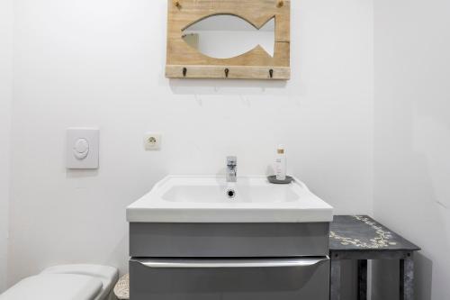 un baño con lavabo e inodoro en L' Eclose Ty Du, en Le Guilvinec