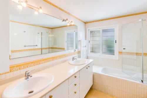 a bathroom with two sinks and a tub and a mirror at Villa Bellver in Palma de Mallorca