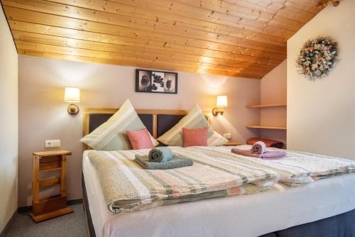 a bedroom with a bed with two hats on it at Gästehaus Erd - Fewo Grünten in Wertach