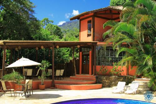 a house with a patio and a swimming pool at Pousada Villaggio Assis in Ilhabela
