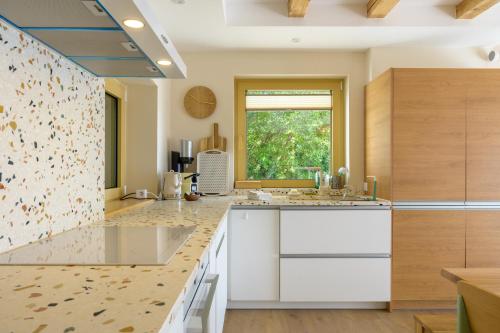 a kitchen with white cabinets and a window at Refuge Mil100 Chalet-spa Luxe 5 in Metzeral