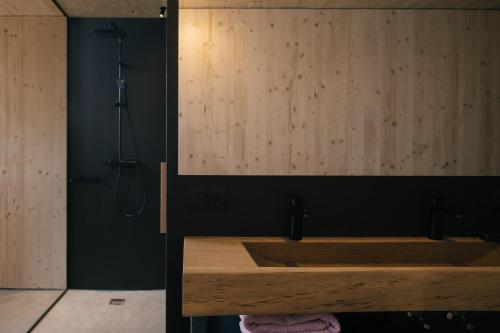 a bathroom with a wooden sink and a shower at anders mountain suites 1 in Brixen