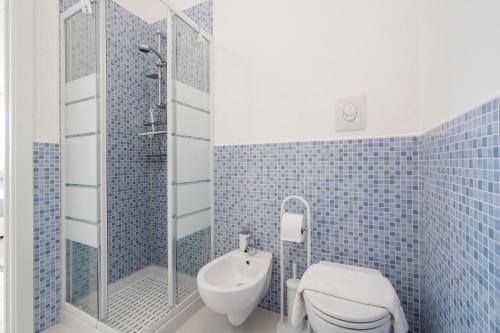 a blue tiled bathroom with a toilet and a shower at Villa Terry in Ostuni