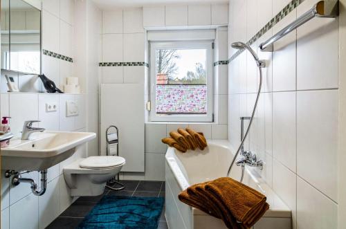 a bathroom with a tub and a sink and a toilet at Li-Do-Bo 01 in Herdwangen-Schönach