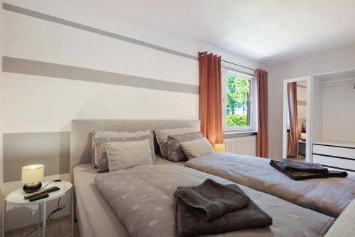 a white bedroom with two beds and a window at Ferienwohnung Wilma Spetzerfehn in Großefehn 