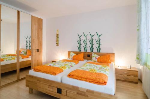 a bedroom with two beds with orange sheets at Ferienwohnung Kramer in Überlingen
