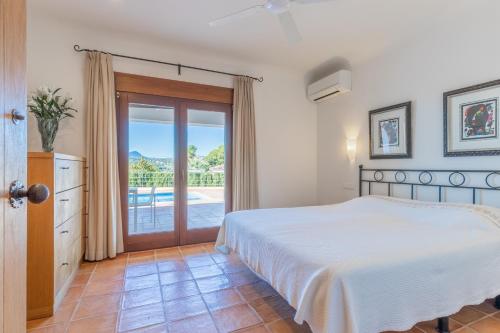 a bedroom with a bed and a sliding glass door at Casa Once Moraira in Teulada