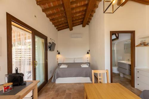 a bedroom with a bed and a bathroom with a sink at Oltremare in Riparbella
