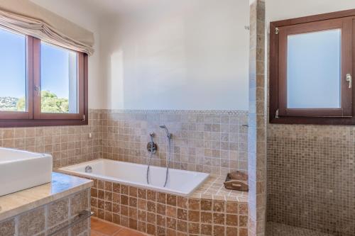 a bathroom with a tub and a sink at Casa Once Moraira in Teulada