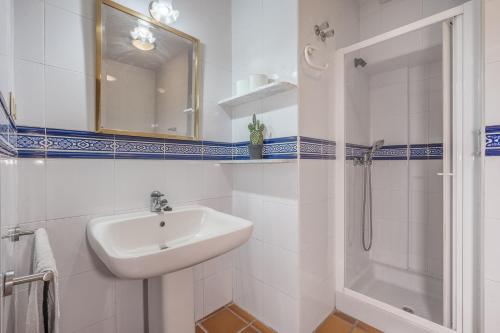 a white bathroom with a sink and a shower at Casa Hitos in Monachil