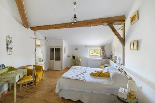 a bedroom with a bed and a desk in a room at Chambres D'hôtes - Le Marlas in Rieucros