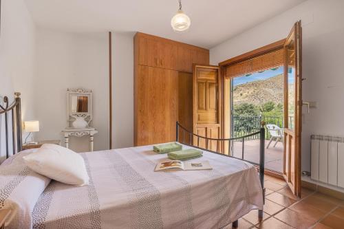 a bedroom with a bed with a view of a balcony at Casa Hitos in Monachil