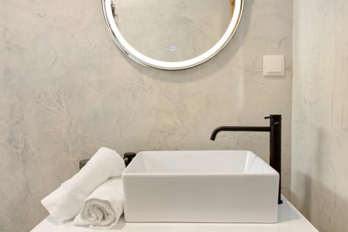 a bathroom with a white sink and a mirror at Casa do Calhau in Câmara de Lobos