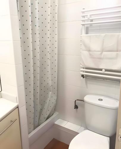 a bathroom with a toilet and a shower curtain at Apartamento Francás in Comarruga