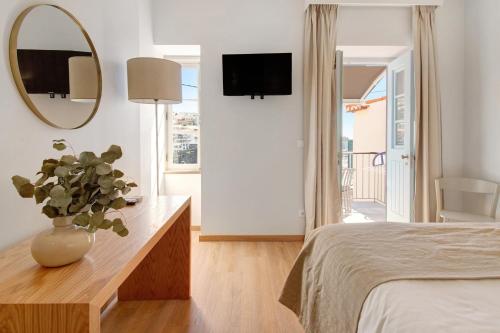 a bedroom with a vase on a dresser and a mirror at Casa do Calhau in Câmara de Lobos