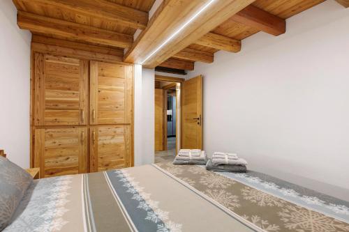 a bedroom with a bed and wooden ceilings at La Maison du Brenand in Rhêmes-Notre-Dame