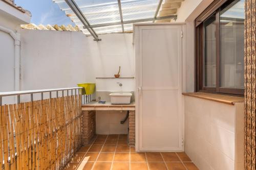 a bathroom with a toilet and a window at Casa Petra in Illora