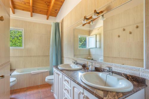 a bathroom with two sinks and a toilet and a tub at Can Juan Pedro in La Mola