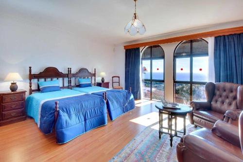 a bedroom with a blue bed and a couch at Villa Albuar in Patroves