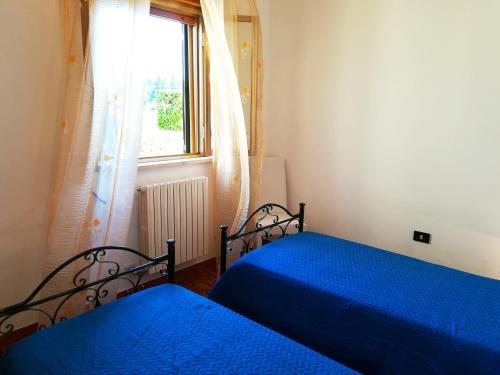 two beds in a bedroom with a window at Incantevole Villa Maddalena in Otranto