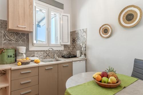 a kitchen with a bowl of fruit on a table at Porto Galini Kalloni in Agios Ioannis