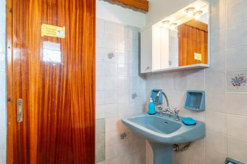 a bathroom with a sink and a wooden door at Princess House in Sidari