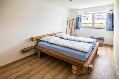 a bedroom with a wooden bed in a room with a window at Ferienwohnung Häfele 1 in Bad Wurzach