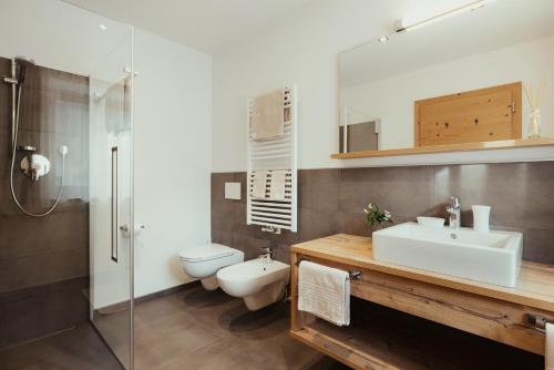 a bathroom with a sink and a toilet at Chalet La Flüta Arnica in La Valle