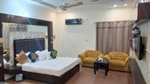 a bedroom with a bed and two couches in it at Hotel Royal One in Multan