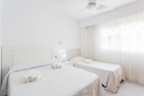 two beds in a white room with towels on them at Las Alondras in Gandía