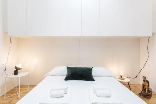a bedroom with a large white bed with white cabinets at Mandello amorevole dimora in Lecco in Lecco