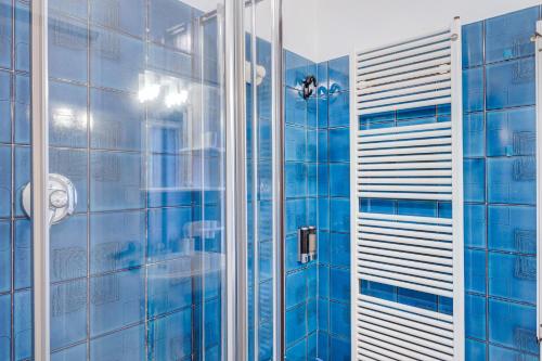 a shower in a bathroom with blue tiles at Domus Regina Elena in Sanremo