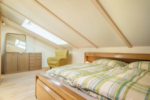 a bedroom with a bed and a mirror and a chair at Luxuriöses Penthouse-appartement in Höchst