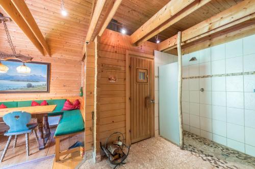 a wooden room with a table and a bathroom at Ferienwohnung Förchensee in Ruhpolding