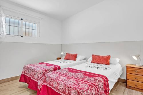 a bedroom with two beds with red and white sheets at Loft Rural in El Soto