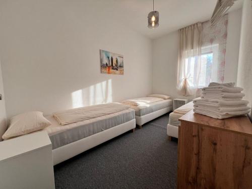 a bedroom with two beds and a wooden table at Dreams Lodge in Koetz 