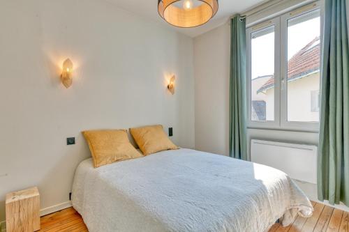 a bedroom with a bed and a large window at Appartement Le Dauphin in Pornichet