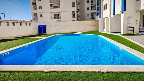 a swimming pool in the yard of a building at Apartamento Solário in Armação de Pêra