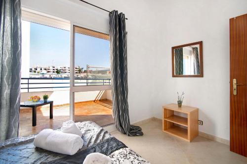 a living room with a bed and a large window at Apartamento Solário in Armação de Pêra