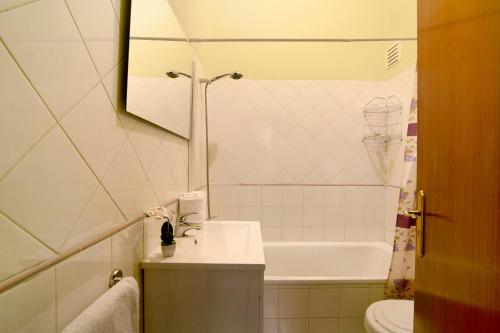 a bathroom with a sink and a toilet and a tub at Apartamento Solário in Armação de Pêra