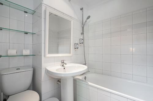 a white bathroom with a sink and a toilet and a tub at Apartamento 2 Casa Las Indianas in Selores