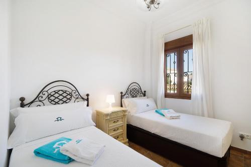 a bedroom with two beds and a window at Carolina Beach House in Chiclana de la Frontera