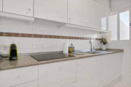 a white kitchen with a sink and a counter at Clementina Imperial Park in Calpe
