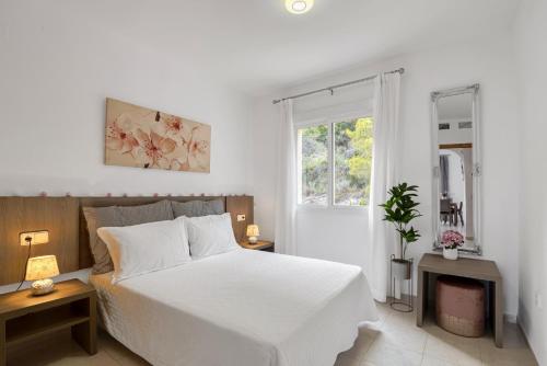 a white bedroom with a white bed and a window at Clementina Imperial Park in Calpe