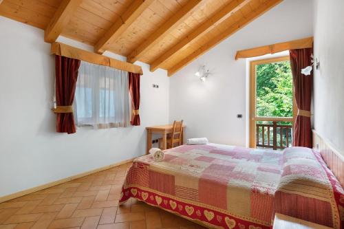 a bedroom with a bed and a window at Agritur Sotto il Melo in Caldes