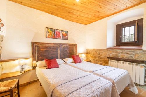 a bedroom with a large bed with red pillows at Sant Grau ii in Navés