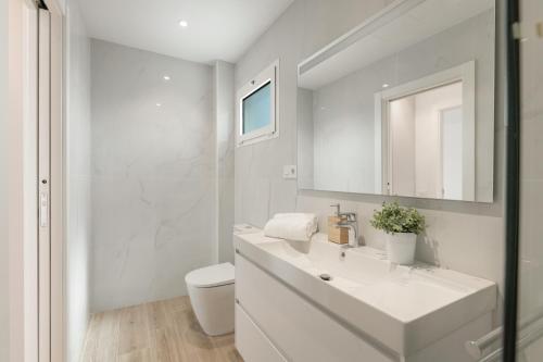 a white bathroom with a sink and a toilet at Casa Ancla in Tías